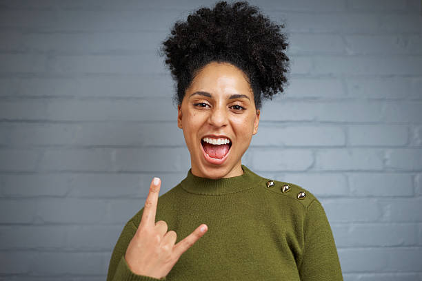 istock Excited Individual Expressing Joyful Energy with Hand Gestures Against Gray Background 2205189051