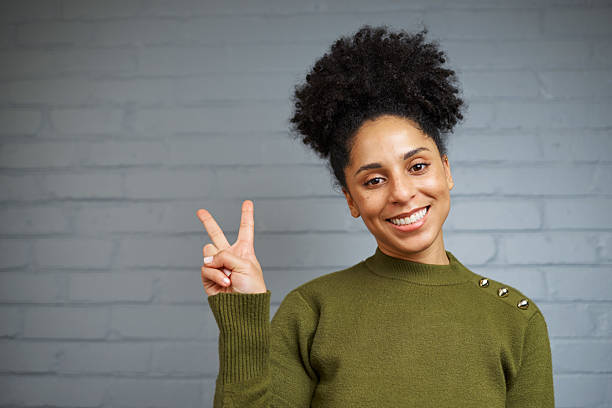 Cheerful Young Woman Making a Peace Sign With a Joyful Expression