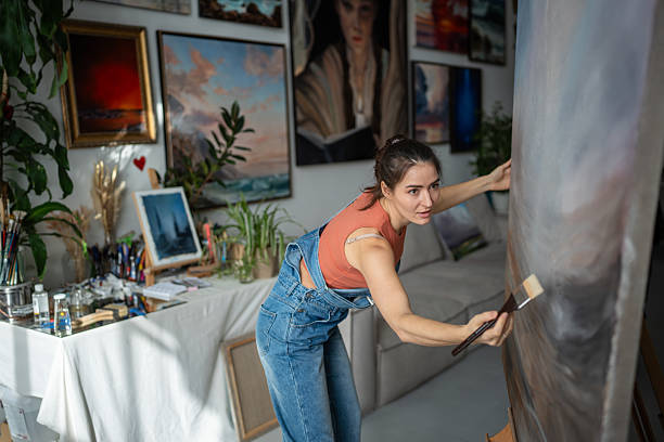 istock Talented woman painter artist working on modern abstract painting in loft studio, custom works 2205189823