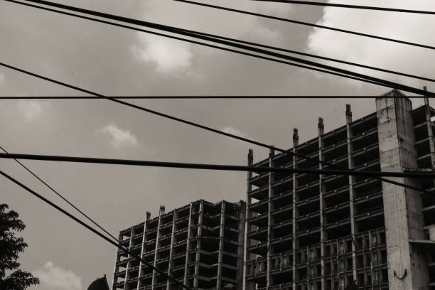 Monochrome unfinished apartment building. Towering apartment in black and white. Building under constructions. Construction Industry. Shadow and silhouette. Architecture Backgrounds