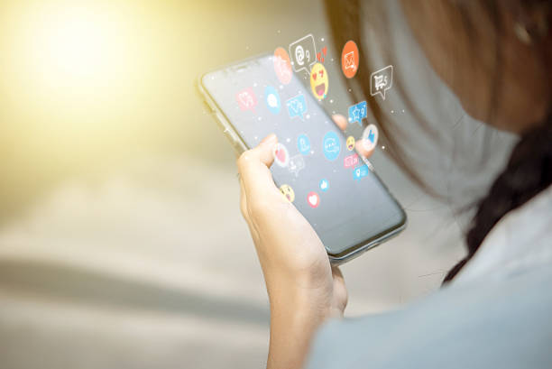istock Online communication through a mobile phone with interactive social networking apps. Social media engagement showing likes, messages, and notifications on a digital screen. 2205191536