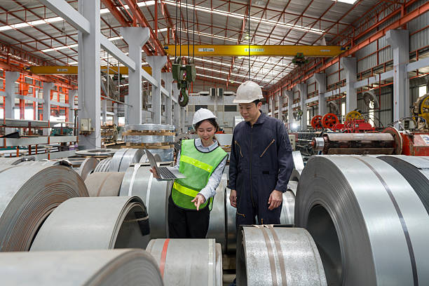 istock Two people are working in a factory. They are discussing plan while looking at a laptop. They wear safety helmet. 2205191806