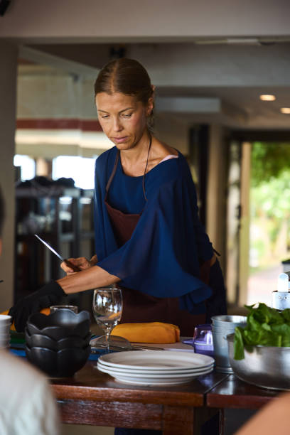 istock Woman preparing a meal with focus and dedication in a modern kitchen setting 2205197866