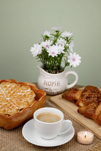A cup of coffee, waffles and croissants on the table. Breakfast with coffee. Homemade pastries. Top view. High quality photo