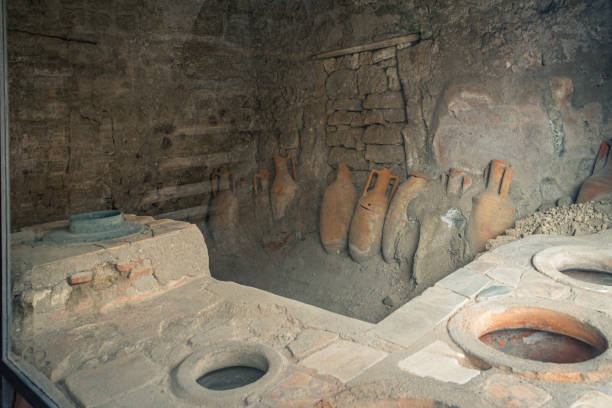 Ancient storage room showcasing amphorae and remnants of a Roman thermal bath, located in Pompeii, Italy.