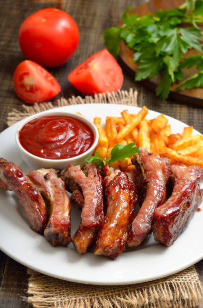 istock Roasted pork ribs and tomato sauce on plate 2205209398