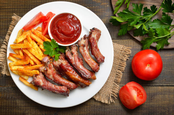 istock Roasted pork ribs and tomato sauce on plate 2205209406