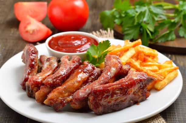 istock Roasted pork ribs and tomato sauce on plate 2205209407