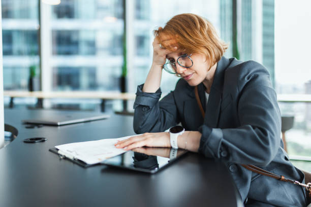 istock Stressed Woman in Modern Office with Headache 2205210048
