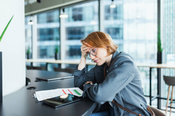 istock Stressed Woman in Modern Office with Headache 2205210074