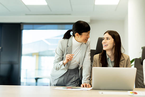 Two colleagues sharing a light moment in a modern office environment during a productive day