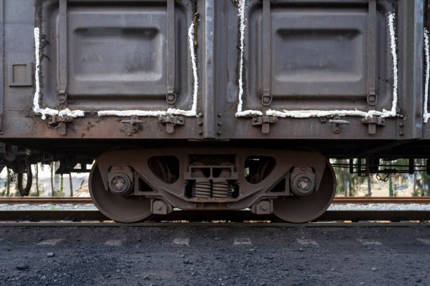 Amidst a backdrop of vibrant greenery, a weathered train coupling rests on rusty tracks, evoking a sense of nostalgia for the journeys once taken on these rails.