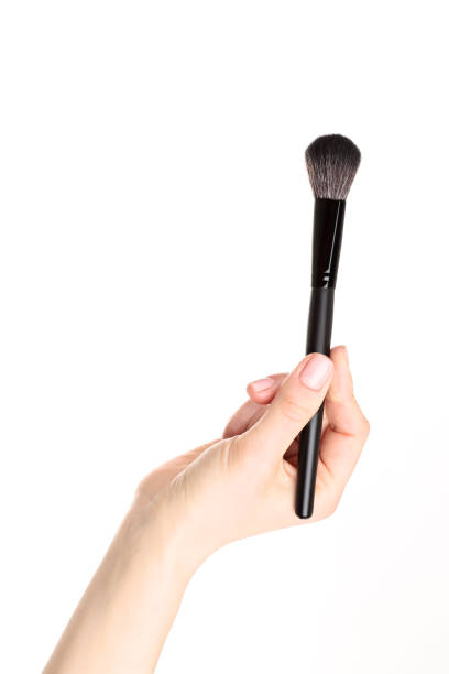 istock Makeup brush in female hand on white background 2205217029