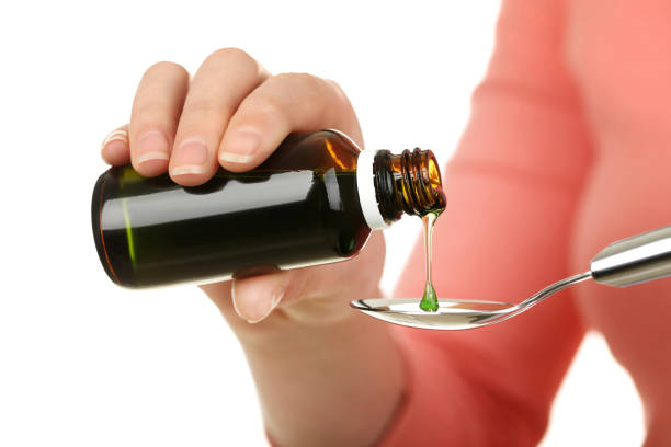 istock Female hands pouring medical syrup in spoon 2205217687