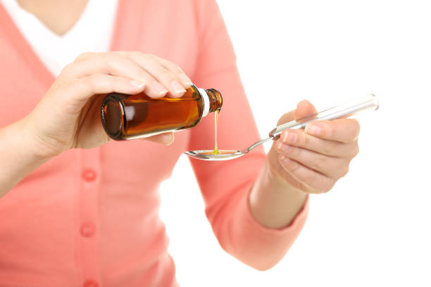 istock Female hands pouring medical syrup in spoon 2205217814