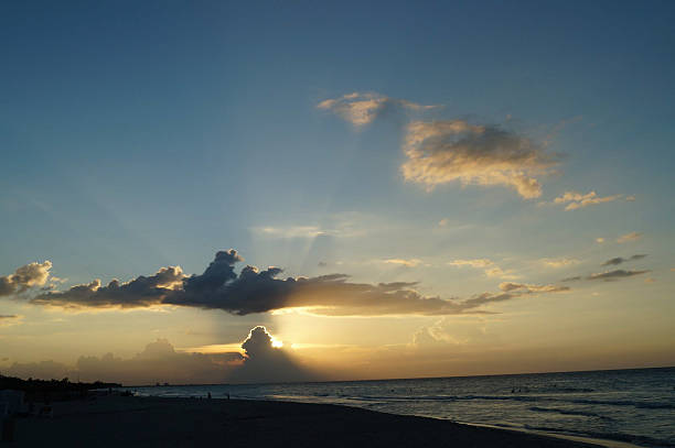 Sunset Over the Ocean Showcasing Dramatic Clouds and Golden Hues During a Tranquil Evening in a Beach Paradise