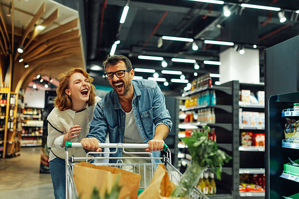 istock Happy couple having fun while shopping in supermarket 2205225080