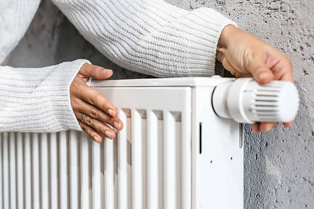 istock A hand adjusting the temperature on a radiator. A concept highlighting energy saving, heating systems, and home comfort. 2205225833