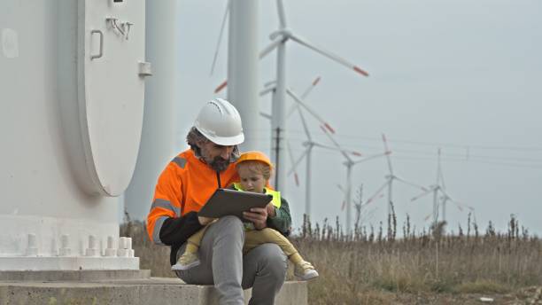 istock Green energy. Engineer Dad with Kid in Wind Farm. 2205228188