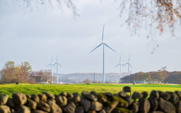 istock Wind power turbines by a green field. 2205229954