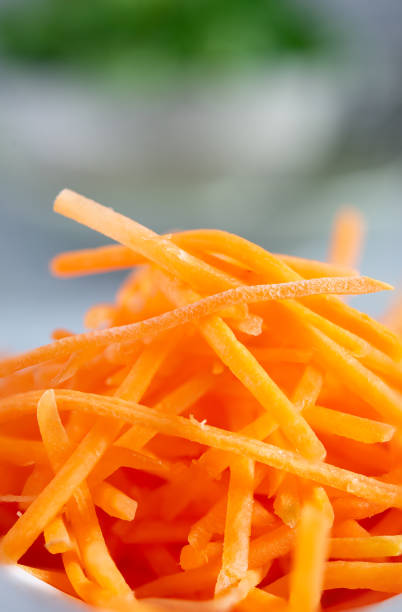 Close-up of a pile of julienne carrots, showcasing their vibrant orange color and thin, matchstick-like shape