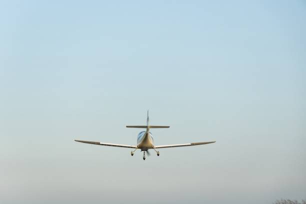 Tel Aviv, Israel - July 20, 2024: A red and white colored light airplane at flight in a clear, blue sky.