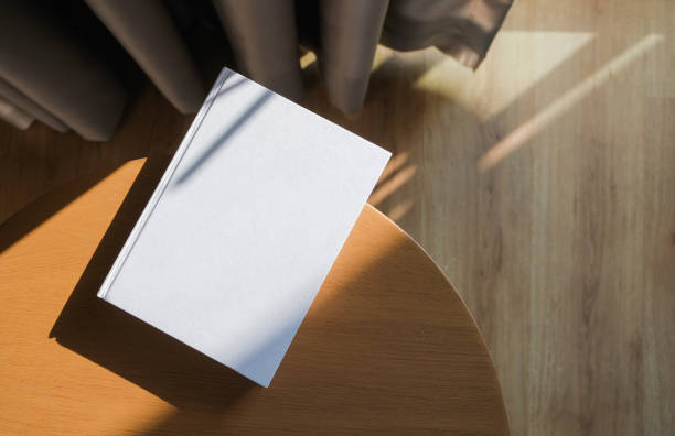 istock blank book mockup on wooden coffee table , shadow overlay 2205248559
