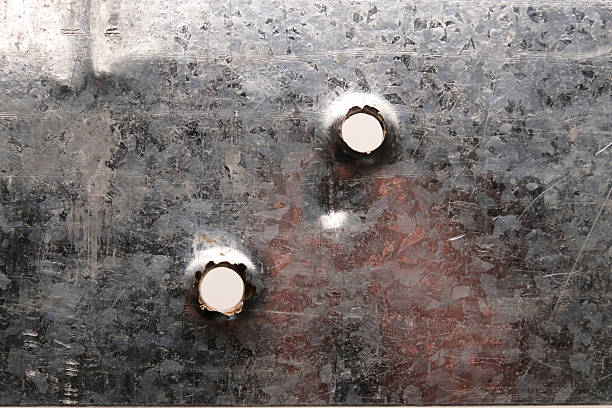 istock Bullet holes on gray sheet metal, close-up 2205248612