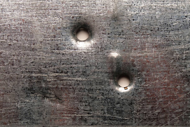 Bullet holes on gray sheet metal, close-up