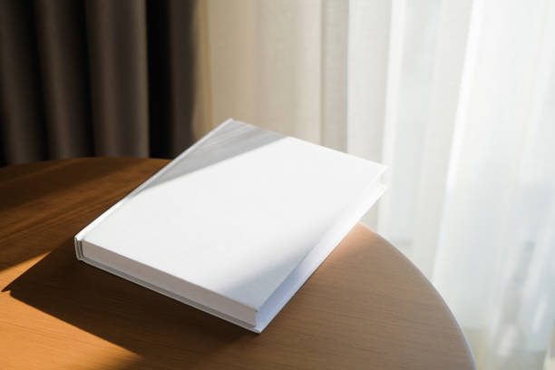 istock blank book mockup on wooden coffee table , shadow overlay 2205248671