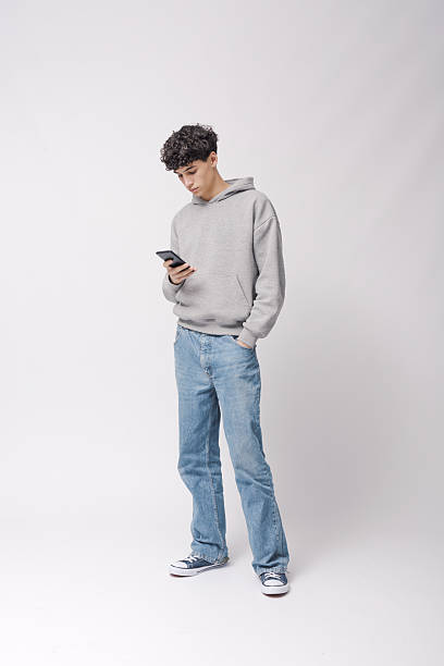 istock Teenager checking messages on his smartphone 2205250894