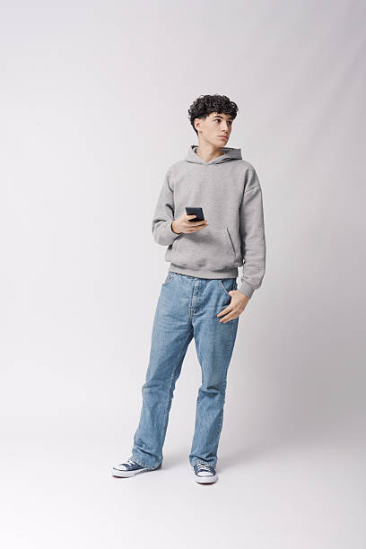 istock Teenager holding his smartphone and standing 2205250911