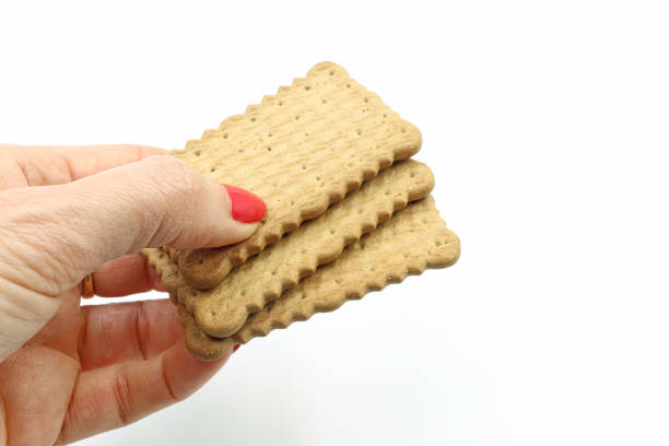 Woman's hand offering some cookies, on white background.