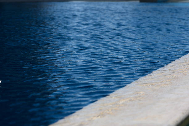 Surface texture of silky smooth soft ocean surface with sunlight, abstract background with copy space, full frame horizontal compositionSurface texture of silky smooth soft water surface with sunlight, abstract background with copy space, full frame horizontal composition