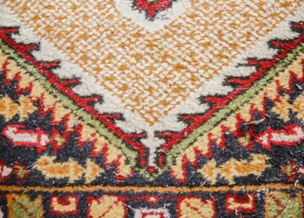 Detailed view of a handmade carpet showcasing vibrant traditional motifs, highlighting craftsmanship and cultural heritage.