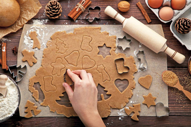 istock Baking christmas cookies on brown wooden table 2205254419