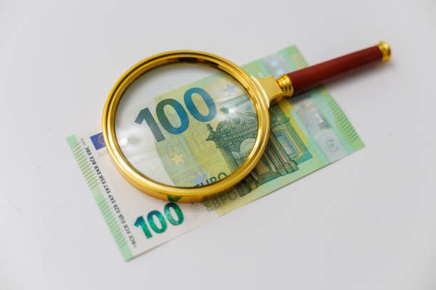 istock One hundred euro banknote under the magnifying glass 2205259752