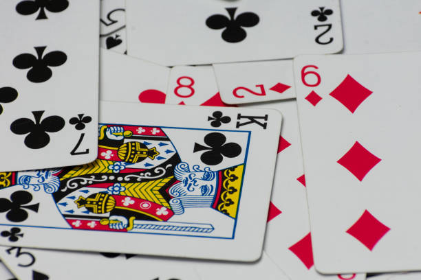 Scattered collection of playing cards, featuring various suits, numbers, and partial card faces. Chaotic arrangement creates a dynamic scene, symbolizing the unpredictability and thrill of card games
