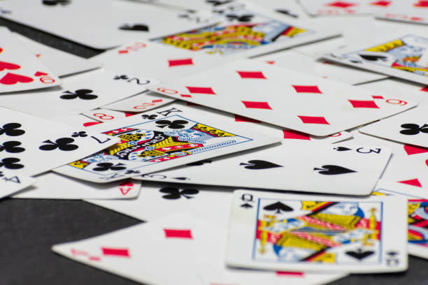 istock Scattered collection of playing cards, featuring various suits, numbers, and partial card faces. Chaotic arrangement creates a dynamic scene, symbolizing the unpredictability and thrill of card games 2205264020