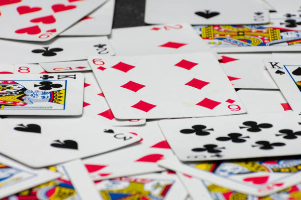 istock Scattered collection of playing cards, featuring various suits, numbers, and partial card faces. Chaotic arrangement creates a dynamic scene, symbolizing the unpredictability and thrill of card games 2205264028