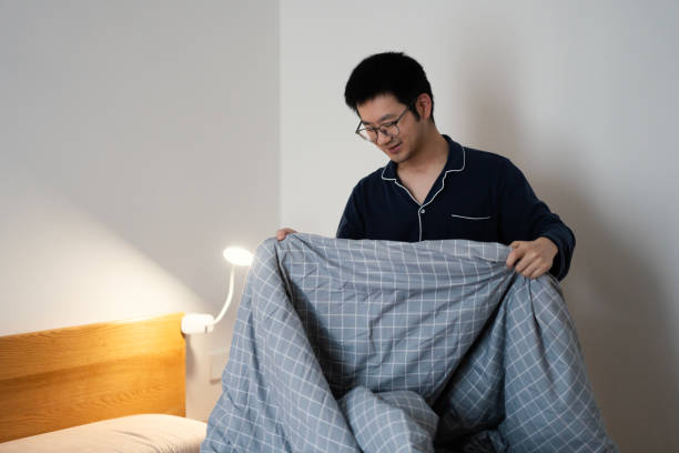 istock An Asian man making the bed in the bedroom 2205264580