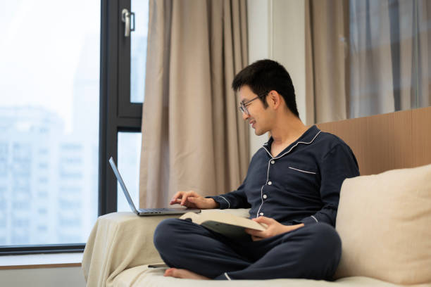 istock An Asian man using a laptop in the living room 2205264657