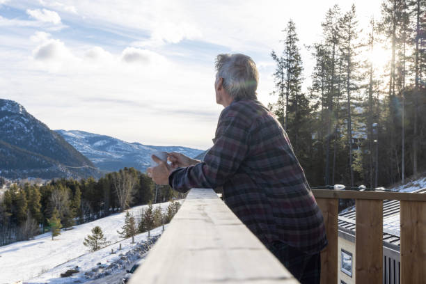 istock Mature man enjoys hot beverage on deck at sunrise in winter 2205271774