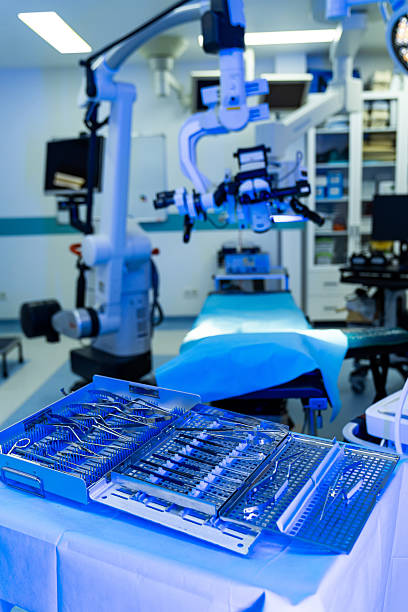 istock Surgical tools ready in OR. Surgical instruments are arranged on a table in a neurosurgery operating room, ready for the procedure. 2205277850
