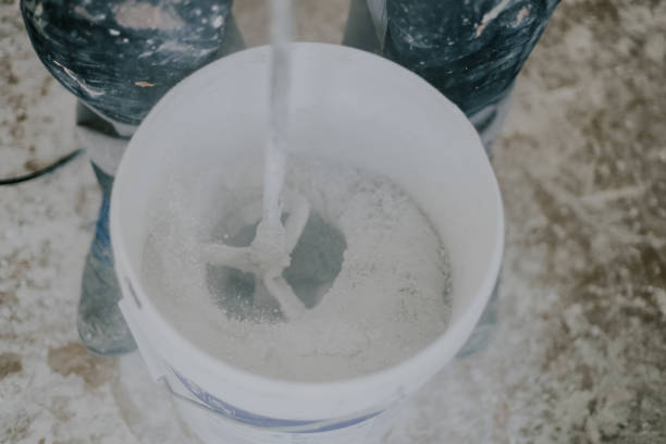 istock A young man mixes putty with a construction mixer in a bucket. 2205289057