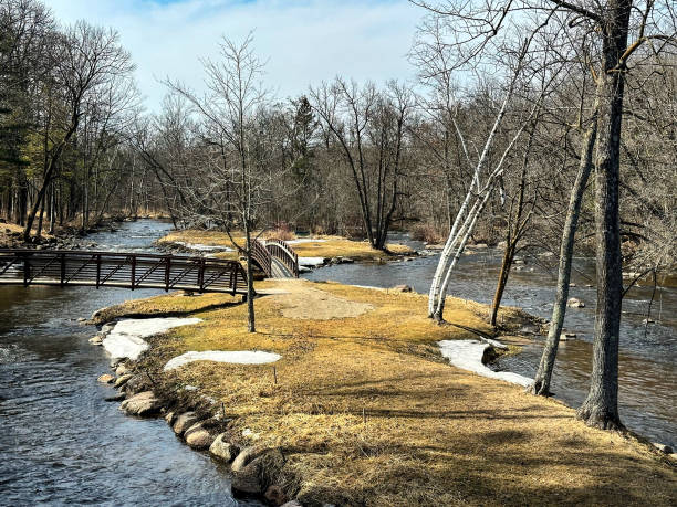 This beautiful bridge is located in Brainard's Bridge Park in Waupaca, Wisconsin. It is a gorgeous sunny day in spring. The sky is a vivid blue color.