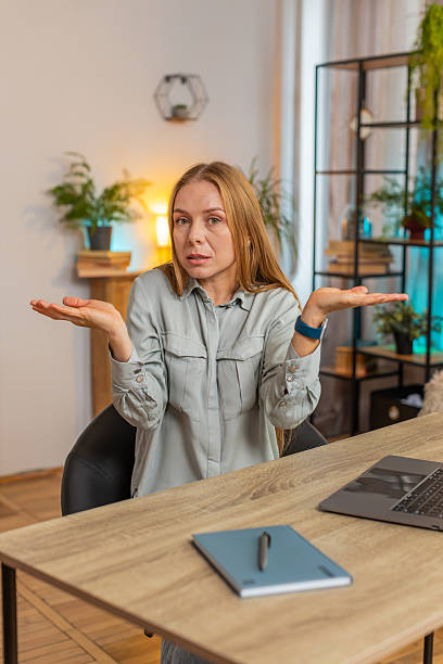 istock Uncertain Caucasian woman freelancer shrugging shoulders dont know how to work at office table 2205292776