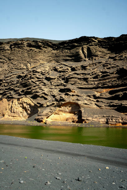 Emerald green pond in rugged volcanic landscape, Lanzarote Island, Canary Islands
