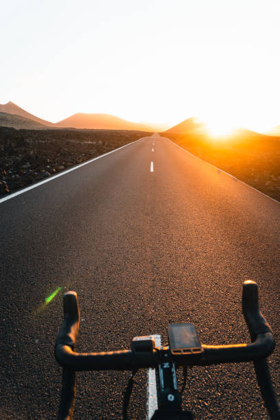 istock View past bicycle handlebars looking down road at sunrise 2205299152