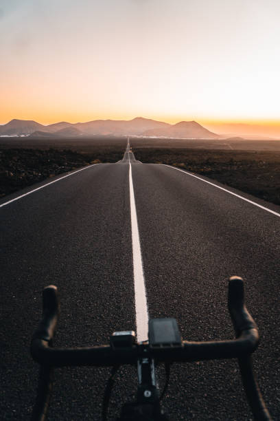 istock View past bicycle handlebars looking down road at sunrise 2205299188